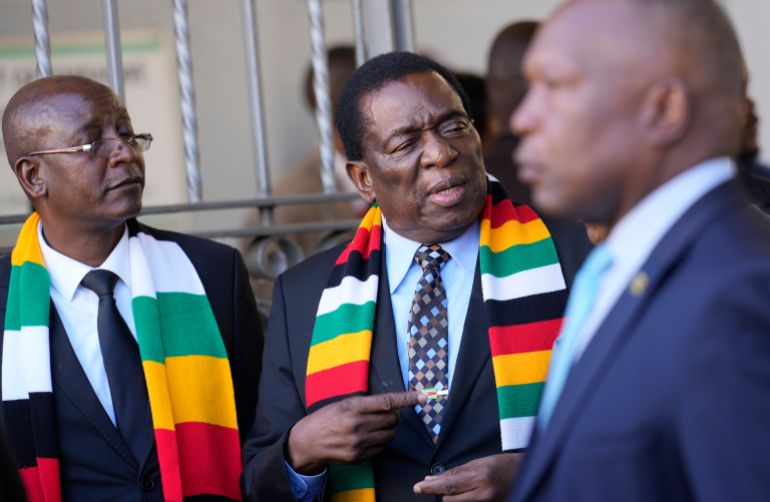 FILE - Zimbabwean President Emmerson Mnangagwa, center, stands next to his chief election agent and Justice Minister Ziyambi Ziyambi, left, outside the nomination court in Harare, Zimbabwe, June 21, 2023. (AP Photo/Tsvangirayi Mukwazhi, File)
