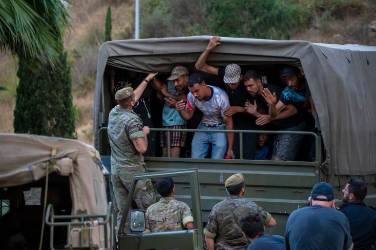 ap_6a710b83344a7-1785793411 Migrants who crossed into Spain are escorted by Spanish soldiers towards the Spanish-Moroccan border for their return to Morocco from the Spanish enclave of Ceuta, Sunday, Aug. 2, 2026. (AP Photo/Antonio Sempere)