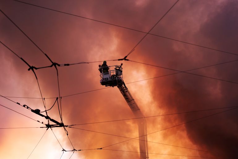 Firefighters try to put out a fire at a city book market following a Russian missile attack in Kyiv, Ukraine early Sunday, Aug. 16, 2026. (AP Photo/Francisco Seco)