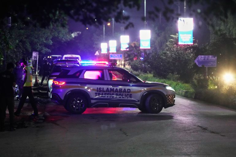 A police vehicle guards a road outside the Shifa International Hospital, where imprisoned former Prime Minister Imran Khan will be transferred for a medical examination following Pakistan's Supreme Court order, in Islamabad, Pakistan, Thursday, Aug. 20, 2026. (AP Photo/Anjum Naveed)