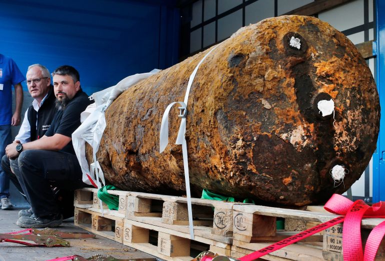 FILE - Members of a bomb disposal unit, Dieter Schwaetzler, left, and Rene Bennert sit next to 1.8 ton World War II bomb after defusing it in Frankfurt, Germany, Sept. 3, 2017. (AP Photo/Michael Probst, File)