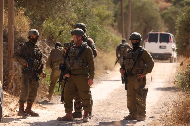 epa_6a7cbba050ca-1786559392 epa13163905 Israeli soldiers block a road as Israeli settlers besiege a Palestinian home for the fourth consecutive day in the town of Qusra, south of Nablus, 12 August 2026. According to the Wafa news agency, Israeli settlers raided the vicinity of three Palestinian houses in the Ras al-Ain area of Qusra, imposed a siege around them, prevented residents from reaching the properties and erected a tent nearby under the protection of Israeli forces. EPA/ALAA BADARNEH