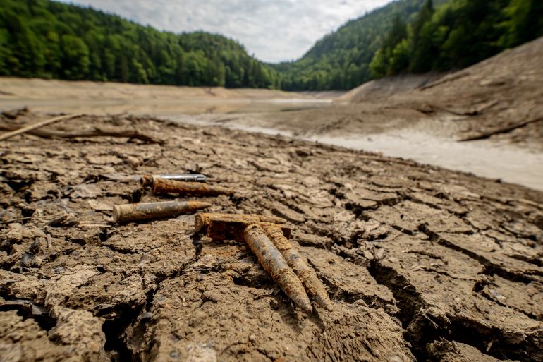 getty_6a6f7090ea-1785688208 BAD ISCHL, AUSTRIA - AUGUST 02: Munitions lie on the exposed lake bottom of the severely shrunk Nussensee mountain lake during ongoing drought and hot weather on August 2, 2026 near Bad Ischl, Austria. The heat waves of this summer combined with a lack of rain have led to a drying out of many tributary sources of water to the Danube River. Danube water levels have dropped so low that commercial shipping is being impacted and hydroelectric plants are reducing or even stopping electricity production. (Photo by Christian Bruna/Getty Images)