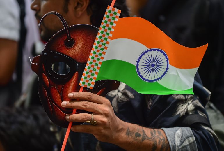getty_6a71a0b812-1785831608 NEW DELHI, INDIA - JUNE 06: A supporter of CJP holds a cockroach mask and the Indian national flag during a protest demanding the resignation of the Education Minister over alleged examination paper leaks, on June 06, 2026 in New Delhi, India. The Cockroach Janta Party (CJP) is a viral, Gen Z-led parody movement founded by political communications strategist Abhijeet Dipke, which uses a cockroach as its mascot to mock political dysfunction. (Photo by Ritesh Shukla/Getty Images)