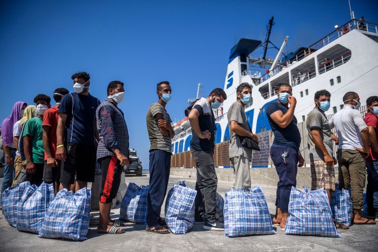 getty_6a7a06fbd0-1786382075 LAMPEDUSA, ITALY - 04: Migrants wait to board a commercial ship before being transferred from the so-called "Hotspot" operational facility, containing over 1,500 people, on August 4, 2022 in Lampedusa, Italy. The Italian island of Lampedusa reached 500 percent over capacity in migrant reception centres with the recent uptick in sea rescues, with former Interior Minister Matteo Salvini, leader of the League party, capitalising on this situation with a visit during election campaigning ahead of snap elections. (Photo by Antonio Masiello/Getty Images)