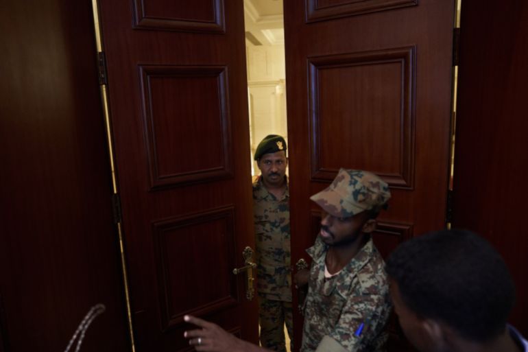 getty_6a7e3c2d26-1786657837 KHARTOUM, SUDAN - MAY 07: Spokesmen for the Transitional Military Council slip through a door into the back of the Republican Palace after a press conference on May 07, 2019 in Khartoum, Sudan. (Photo by David Degner/Getty Images)