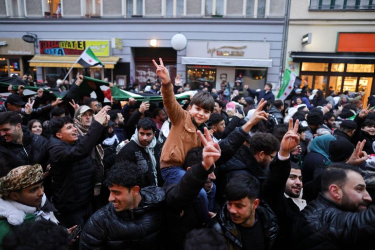 getty_6a81b2375a-1786884663 BERLIN, GERMANY - DECEMBER 8: Expatriate Syrians gather with flags to celebrate the fall of the Assad regime in Syria on December 8, 2024 in Berlin, Germany. Germany took in hundreds of thousands of Syrians following the outbreak of the civil war, with flows of refugees intensifying in and after 2015. The rebel sweep of cities across Syria over the last few days was sudden and is likely to upend the balances of power across the Middle East. (Photo by Omer Messinger/Getty Images)
