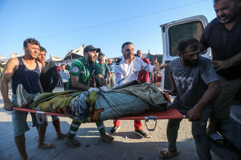 GAZA CITY, GAZA - AUGUST 18: (EDITOR'S NOTE: Image depicts death.) Paramedics carry the body of a person reportedly killed in an Israeli airstrike on August 18, 2026 in Gaza City, Gaza. The Israeli Army have put out a statement announcing the deaths of one Hamas Commander and three faction Leaders, killed while they met in a beachside cafe in a tent. (Photo by Ahmad Hasaballah/Getty Images)