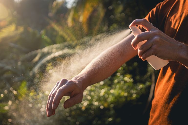 gettyimages-1949513976-1786044847 بعوض Man while applying insect repellent on his hand. Prevention against mosquito bite in tropical destination.