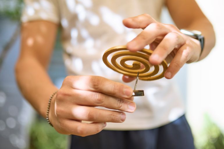 gettyimages-2258516427-1786044854 بعوض Hands preparing mosquito coil before use