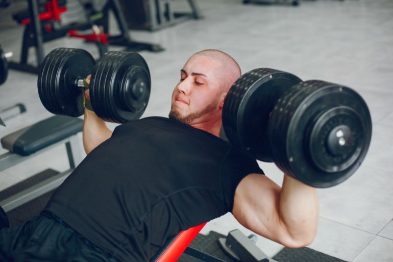 gym-3-1787402416 A young and muscular guy in a black t-shirt trains in a gym المصدر: Magnific AI