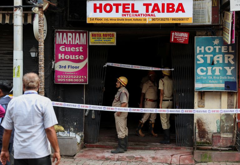 Firefighters stand at an entryway to a hotel where a fire broke out and killed several people, in Kolkata, India, August 19, 2026. REUTERS/Sahiba Chawdhary REFILE - QUALITY REPEAT TPX IMAGES OF THE DAY