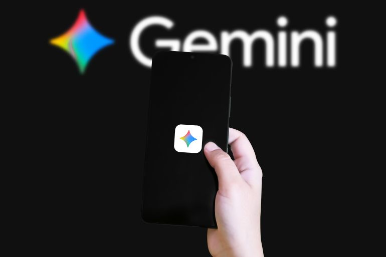jkhvgcjk-1779447104 Hand holding smartphone with Gemini app logo in blurred background highlighting cryptocurrency trading platform concept; Shutterstock ID 2754649989; purchase_order: سs; job: s; client: s; other: