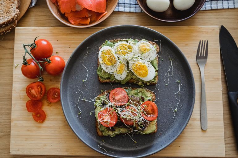 pexelsss-1785957739 Delicious avocado toast topped with fresh eggs and tomatoes, perfect for a healthy breakfast or lunch.