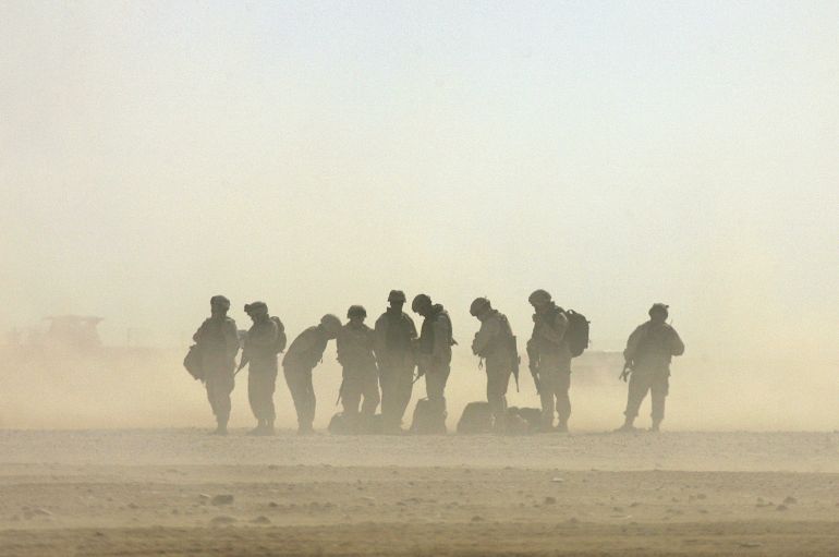 pic-88742-1786048111 U.S army soldiers stand in the sand while waiting for a helicopter landing at Forward Operation Base Ramagen in Tikrit, Iraq, October 23, 2005. A batallion from the Army National Guard based in Pennsylvania began their way back home after one year of service in Iraq on Sunday. REUTERS/Jorge Silva