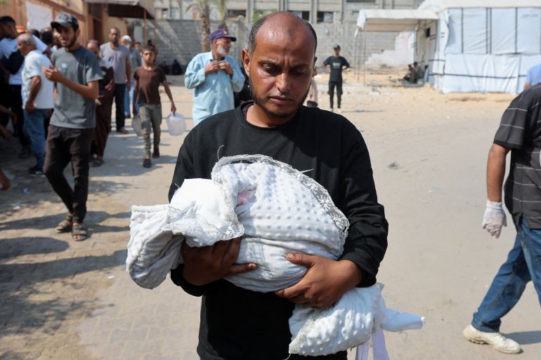 reuters_689061ef-1754292719 Ahmed Abu Haleeb, the father of Palestinian baby Zainab Abu Haleeb, who died due to malnutrition, according to health officials, holds her body, in Khan Younis, southern Gaza Strip, July 26, 2025. REUTERS/Ramadan Abed