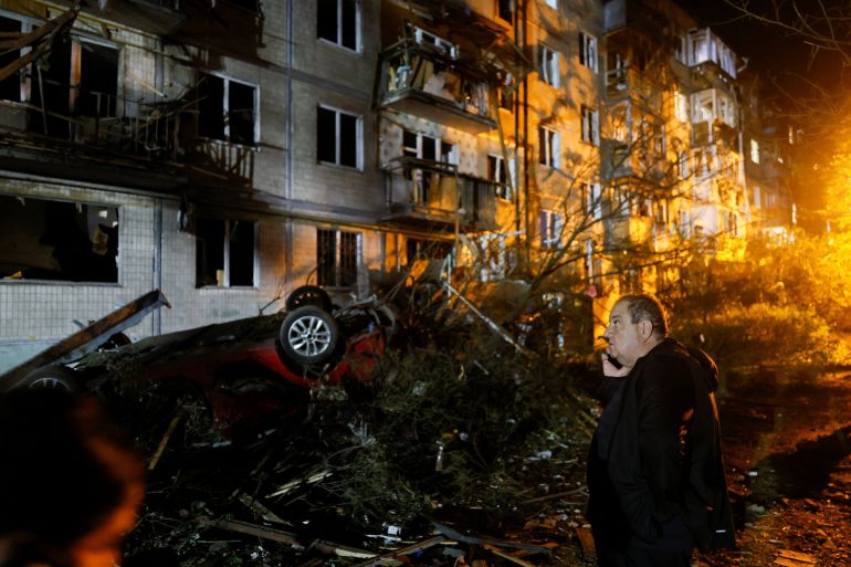 A man uses his mobile phone as he stands at the site of an apartment building hit by a Russian missile strike, amid Russia's attack on Ukraine, in Kyiv, Ukraine, August 1, 2026. REUTERS/Gleb Garanich