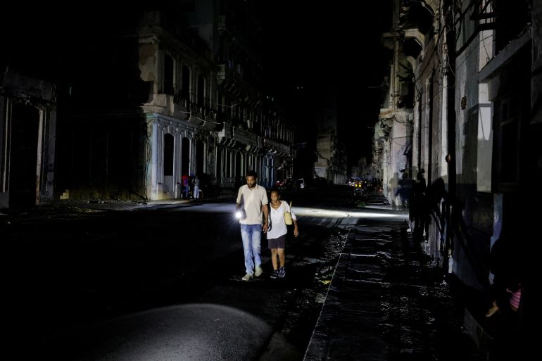reuters_6a702ded-1785736685 FILE PHOTO: People walk down a street as Cuba's national power grid collapsed, marking the third major outage in nine days, in Havana, Cuba, July 14, 2026. REUTERS/Norlys Perez/File Photo