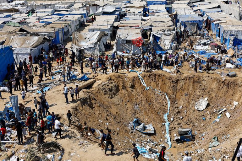 Palestinians inspect the site of an overnight Israeli strike on a medicine warehouse, according to medics, next to tents sheltering displaced Palestinians, in Deir al-Balah, in the central Gaza Strip, August 1, 2026, residents had been pre-warned by the Israeli military to evacuate. REUTERS/Mahmoud Issa REFILE - ADDS INFORMATION