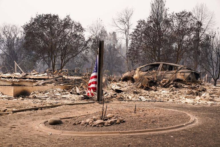 reuters_6a713866-1785804902 An American flag sits among incinerated neigbourhood in the Old Trails Fire, in Spokane, Washington, U.S., August 3, 2026. REUTERS/David Ryder