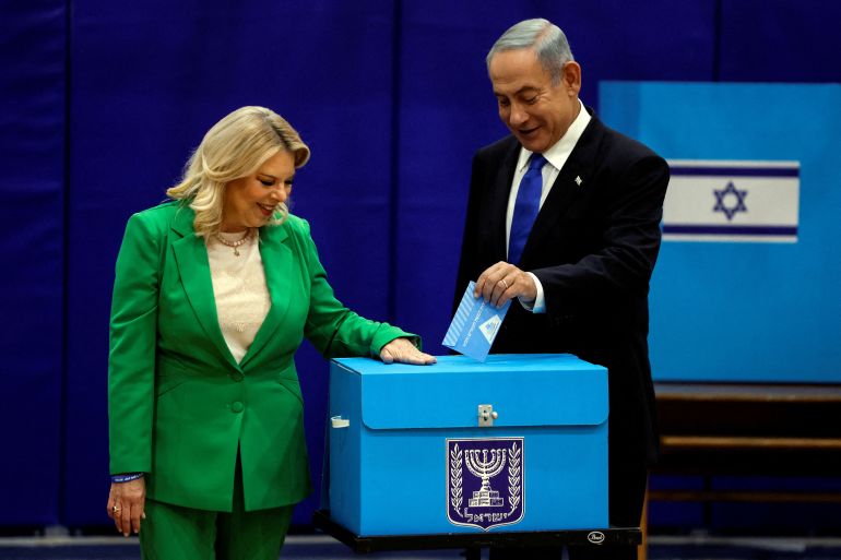 reuters_6a79e3f1-1786373105 FILE PHOTO: Former Israeli Prime Minister Benjamin Netanyahu stands next to his wife Sara as they cast their ballots on the day of Israel's general election in a polling station in Jerusalem November 1, 2022. REUTERS/Ammar Awad/File Photo