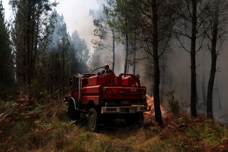 reuters_6a7f1c44-1786715204 A firefighter works to extinguish a wildfire in Luglon, Les Landes department, France August 14, 2026. REUTERS/Stephanie Lecocq
