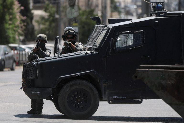 FILE PHOTO: Israeli forces point their weapons as they take part in a raid in Qalandia refugee camp, in the Israeli-occupied West Bank, August 25, 2026. REUTERS/Ammar Awad/File Photo