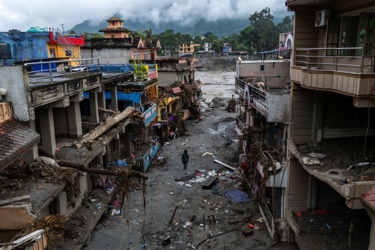 A drone view shows a man walking next to damaged buildings and houses covered in mud near the Likhu River following deadly flash floods and mudslides, in Devighat, Nuwakot district, Nepal, August 30, 2026. REUTERS/Athit Perawongmetha