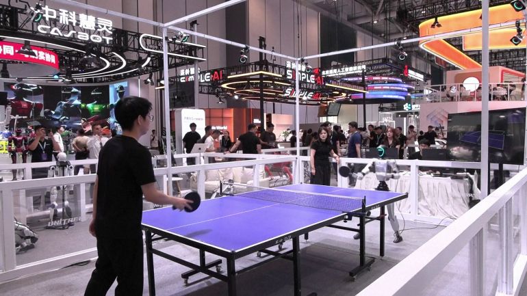 robots-china-1787131672 روبوت بشري يبادل أحد اللاعبين كرات الطاولة خلال المؤتمر العالمي للروبوتات في بكين