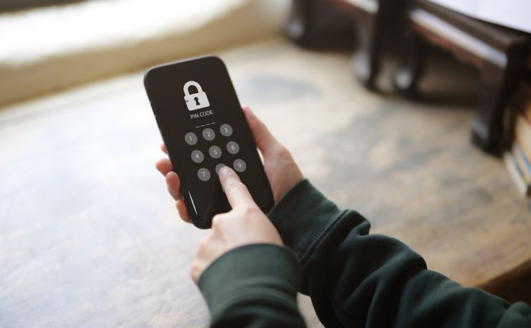 shutterstock_2267414235-1779875363 Device secure access concept, Woman accessing smartphone with pin code. cyber security, hacking phishing, Mobile phone password to access smartphone, security threats online, privacy lock screen,