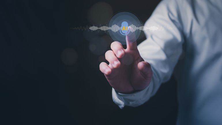 shutterstock_2721633713-1779886609 Close up of a businessman touching a virtual AI voice assistant interface with sound waves. Concept of artificial intelligence speech recognition, smart technology, and futuristic communication.