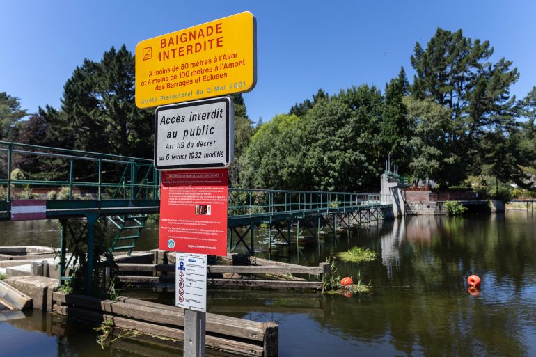 (FILES) This photograph shows a panel reading "Swimming forbidden" near a lock on the River Blavet at Hennebont, western France on July 6, 2026. France has recorded 301 drownings since June 19, 2026, an increase of 14 percent from last year, France's Sports Minister said on August 23, linking the surge to the heatwaves that have swept Europe. (Photo by Fred TANNEAU / AFP)