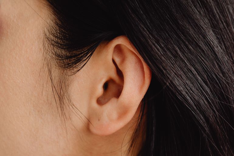 092983-1787319405 Detailed close-up photo showcasing a human ear with dark hair.