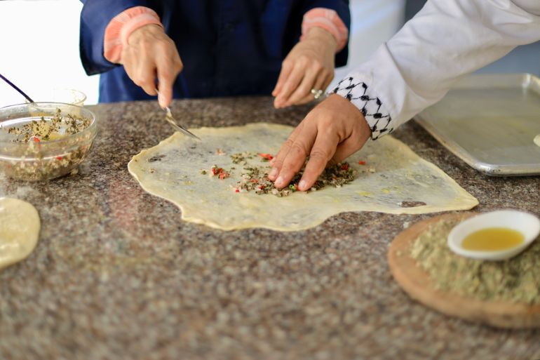 12-1790182921 فلسطين- غزة- حي الرمال- أكاديمية سمايل كيتشن، الطبق الخامس، 22/09/2026 المطبّق الفلسطيني بالزعتر والمكوّن من أوراق الزعتر البلدي الطازجة، وقد دفع شحّها الشوّاف إلى استخدام الزعتر الجاف، وحلّ نوع متاح من السماق محل السماق البلدي، أحد المكونات الرئيسة في الخلطة الفلسطينية إسراء الرّملي- خاص الجزيرة نت.