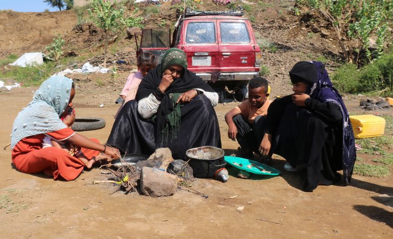 A displaced woman, Nabiha Salem, eats with her children at a makeshift camp for people displaced by clashes between Iran-aligned Houthi fighters and Saudi-backed Yemeni government forces, in Taiz province, Yemen September 21, 2026. REUTERS/Stringer