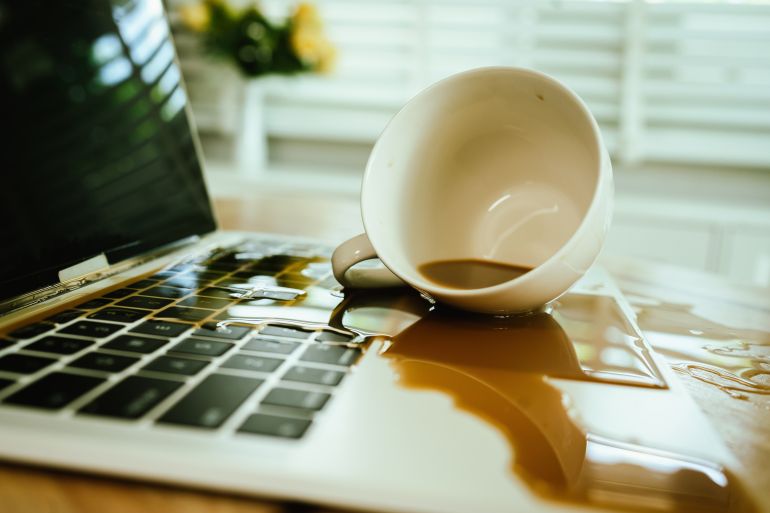 3laptop-1789985797 Morning mishap: hot coffee spills over office laptop and documen adobe stock