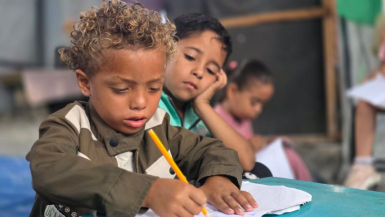 4-1788194610 طفل نازح في خيمة قريبة من مجمع ناصر الطبي يواظب على تعليمه في مدرسة من الخيام تقدم خدمات مجانية للنازحين