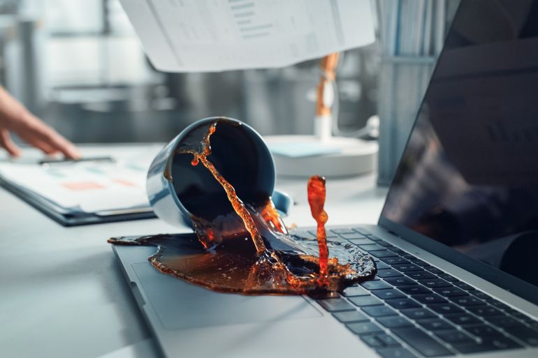4laptop-1789985800 Office Manager Accidentally Spilling Hot Coffee on Working Lapto adobe stock