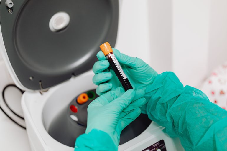 6627690-1789048698 Laboratory scene with a healthcare professional preparing a blood sample for analysis using a centrifuge.