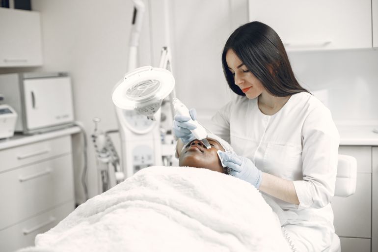6656-1788618315 A skilled practitioner performs a relaxing facial treatment, promoting wellness and skincare in a modern clinic.