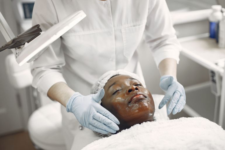7446666-1788617988 A client enjoys a soothing facial treatment in a modern skincare clinic, promoting wellness and relaxation.