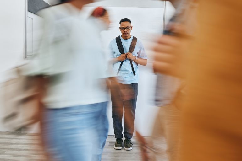 78697765-1789563232 Bullying, depression and sad university student, black man and mental health problems in busy college. Social anxiety, depressed and lonely campus guy, ... See More by Siphosethu Fanti/peopleimages.com @ادوبي ستوك