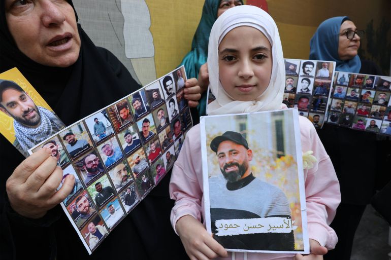 Family members of prisoners and detainees in the Israeli prisons carry the pictures of their relatives during a solidarity protest called for by the Committee of Representatives of Prisoners and Liberated Persons from Israeli prisons, outside the International Red Cross headquarters in Beirut on August 12, 2026. (Photo by Anwar AMRO / AFP)
