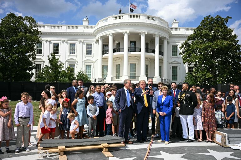 afp_6a8d1dbded0f-1787633085 US President Donald Trump (C) speaks with Nebraska Governor Jim Pillen (L) and Secretary of Education Linda McMahon at the construction site of a helipad on the South Lawn of the White House in Washington, DC, on August 24, 2026.