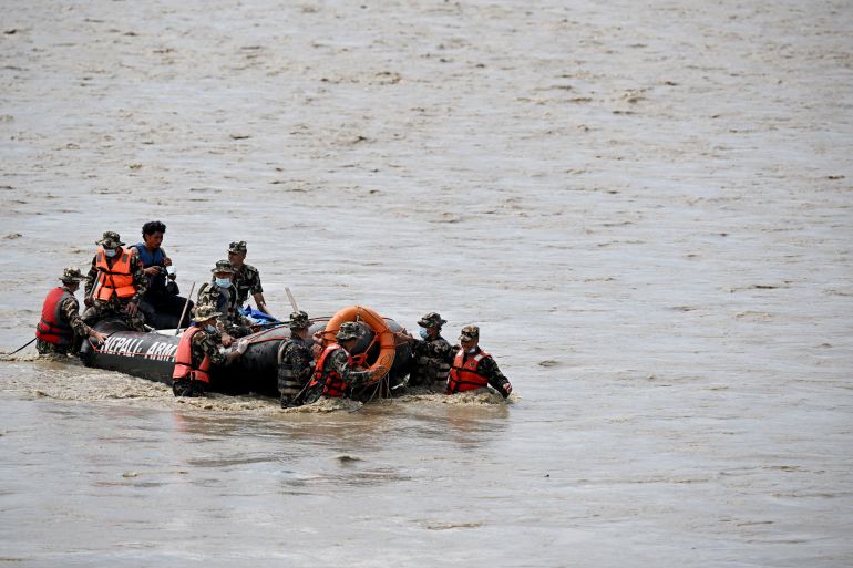 Nepal's army personnel carry the bodies of deceased flood victims during a search operation along the Narayani river at Bharatpur in Nepal's Chitwan district on August 31, 2026.