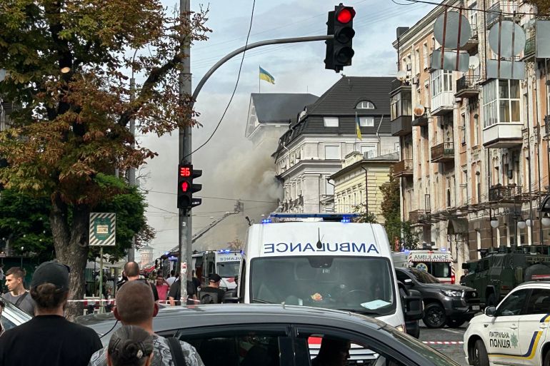 Onlookers watch as Ukrainian rescue personnel work to extinguish a fire in the headquarters of the Security Service of Ukraine (SBU) following an air attack in Kyiv on September 4, 2026, amid the Russian invasion of Ukraine.