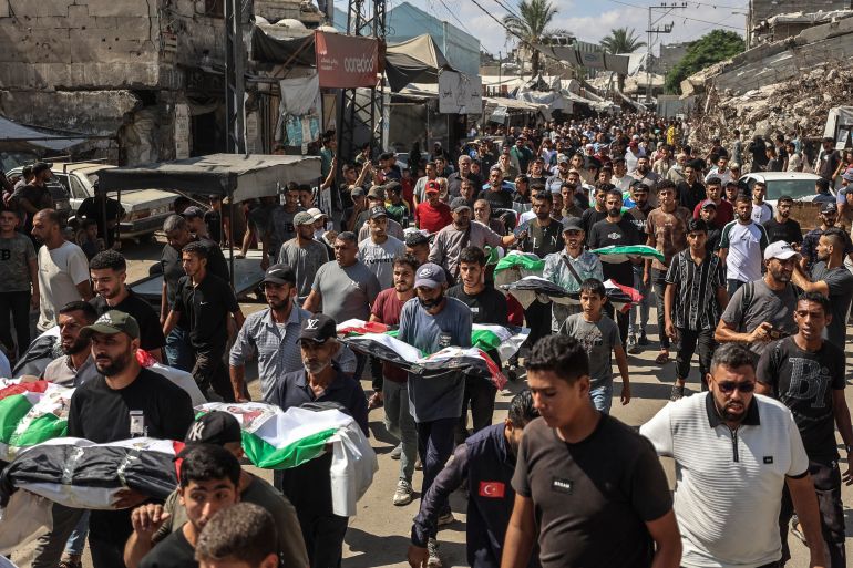 afp_6a9ddd4f6d0c-1788730703 Mourners carry the bodies of their loved ones during a mass burial of around 100 Palestinians, including 62 children, whose remains where recovered from rubble, in Gaza City, on September 6, 2026.