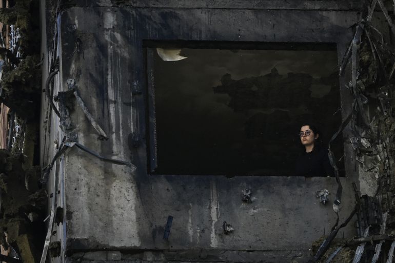 afp_6aa1f61b5bab-1788999195 A woman looks out of a window of a damaged apartment in a highrise residential building, following a Russian drone attack in Kyiv on September 9, 2026, amid the Russian invasion of Ukraine. (Photo by Genya SAVILOV / AFP)