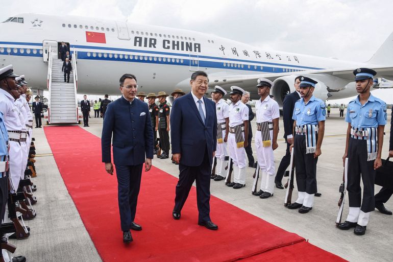 afp_6aa527bcc4b3-1789208508 TOPSHOT - This handout photograph taken and released by Indian Press Information Bureau (PIB) on September 12, 2026 shows Chinese President Xi Jinping (C) walking upon his arrival in New Delhi.