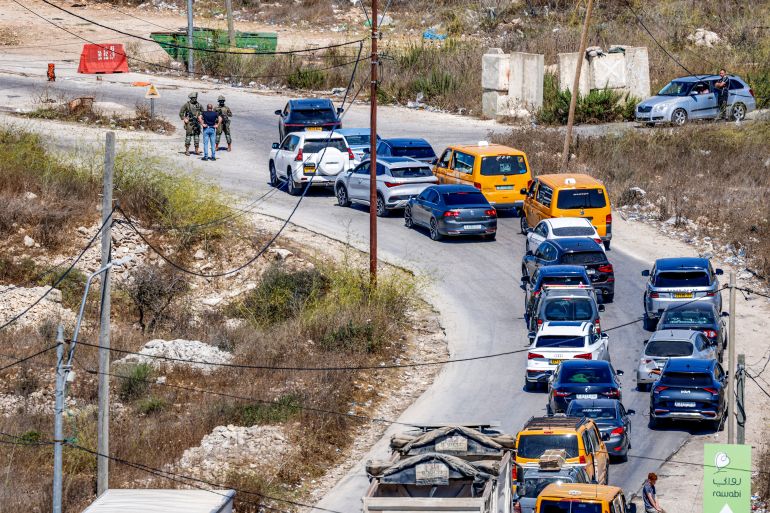 afp_6ab026962ed2-1789929110 Vehicles queue as Israeli soldiers and police close the Atara checkpoint, north of Ramallah in the Israeli-occupied West Bank, and block the road leading to the Israeli settlement of Halamish on September 20, 2026 following a reported attack by a Palestinian in which an Israeli settler was seriously wounded. (Photo by Zain JAAFAR / AFP)